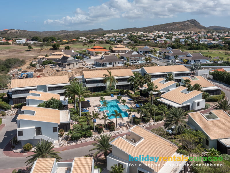 Aerial view of the swimming pool and the holiday homes at the blue bay resort Curacao